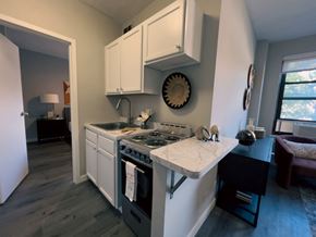 Chicago apartment for rent - a kitchen with white cabinets and a sink and a stove