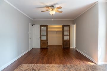 Chicago apartment for rent - an empty living room with a ceiling fan and a closet
