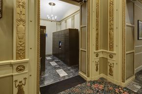 Chicago apartment for rent - the lobby of a building with gold walls and a black door