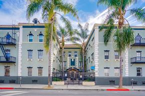Los Angeles apartment for rent - a building with palm trees in front of it on a street