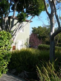 Los Angeles apartment for rent - A house is surrounded by trees and shrubs.