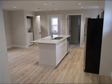 Waterloo apartment for rent - A kitchen with a white counter top and a black refrigerator.