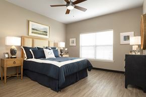 Shiloh apartment for rent - bedroom with light wood flooring and dark bed at Thirteen01 at Hartman Lakes, Shiloh, 62269