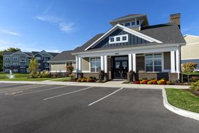 Shiloh apartment for rent - exterior clubhouse with parking in front at Thirteen01 at Hartman Lakes, Shiloh, IL