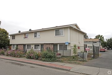 Santa Rosa apartment for rent - A beige house with a blue sign in front of it.