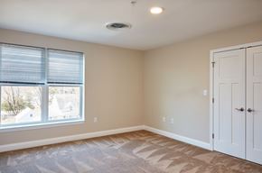 Uxbridge apartment for rent - an empty bedroom with a large window and a white door
