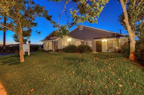Midway City apartment for rent - the front of our house at night with trees and grass