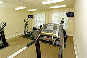 Shelby Twp apartment for rent - a gym with cardio equipment and mirrors in an empty room