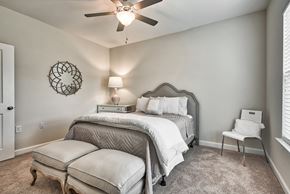 Clayton apartment for rent - A bedroom with a bed, chair, and ceiling fan.