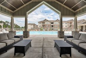 Clayton apartment for rent - A large outdoor patio with a pool and couches.