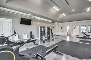 Clayton apartment for rent - A gym with a variety of equipment including treadmills, weights, and a television.