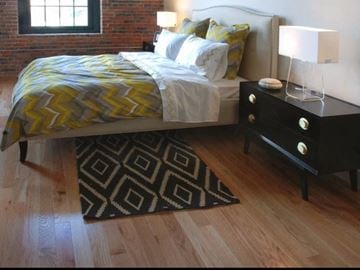 Lowell apartment for rent - A bedroom with a bed, nightstand, and rug.