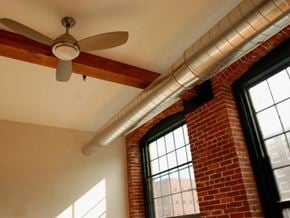 Lowell apartment for rent - A room with a ceiling fan and a window with a brick wall.