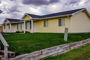 Chadron apartment for rent - a yellow house with a wooden fence in front of it
