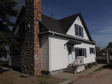 Mitchell house for rent - a white house with a brick chimney