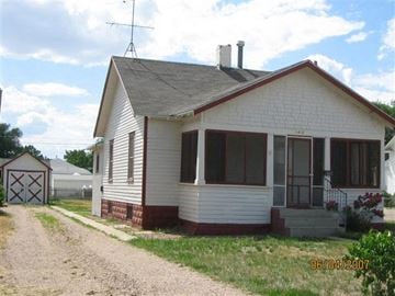 Scottsbluff house for rent - a white house with a dirt road in front of it