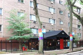 Chicago apartment for rent - A building with a black awning and a rainbow flag on it.