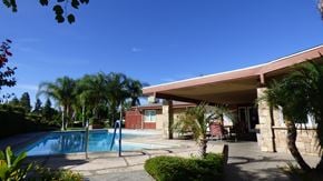 Highland apartment for rent - a swimming pool in front of a hotel with palm trees