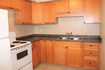 Brandon townhouse for rent - a kitchen with white appliances and wooden cabinets
