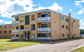 Brandon apartment for rent - a view of a building with a dirt road in front of it