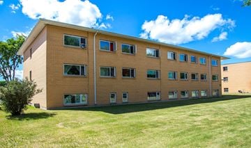 Brandon apartment for rent - a large brick building with green grass in front of it