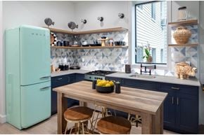 Brooklyn apartment for rent - A kitchen with a blue refrigerator and wooden table.