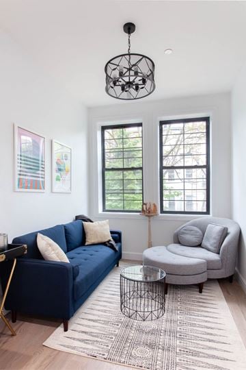 Brooklyn apartment for rent - A living room with a blue couch and a grey armchair.