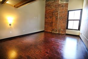Lincoln apartment for rent - an empty living room with a brick wall and wood floors
