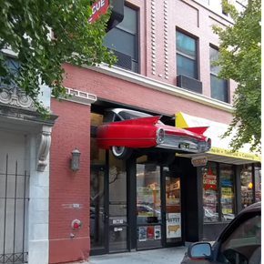 Lincoln apartment for rent - a red car hanging from the side of a building