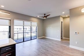 Lincoln apartment for rent - an empty living room with sliding glass doors and a ceiling fan