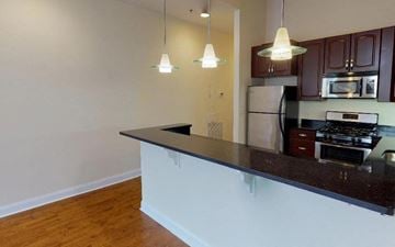 Philadelphia apartment for rent - A kitchen with dark brown cabinets and a black countertop.