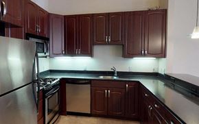 Philadelphia apartment for rent - A kitchen with dark wood cabinets and stainless steel appliances.