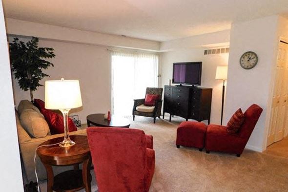 Grand Blanc apartment for rent - a living room with red chairs and a television