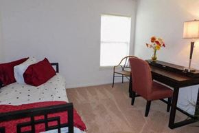 Grand Blanc apartment for rent - a bedroom with a bed and a desk with a chair