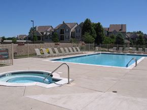 Grand Blanc apartment for rent - a swimming pool with chairs around it and a house in the background