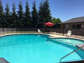 Modesto apartment for rent - a large swimming pool with chairs and a umbrella