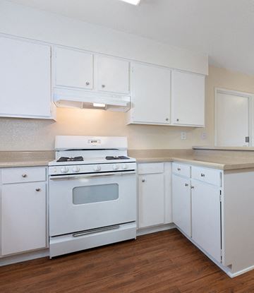 Marina apartment for rent - A white kitchen with a stove and cabinets.