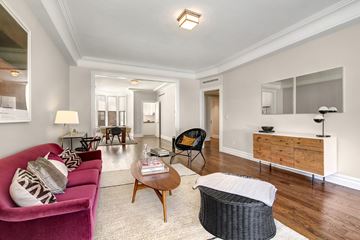 Manhattan apartment for rent - a living room with a pink couch and a wooden table