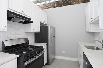 Oak Park apartment for rent - a kitchen with white cabinets and a black stove and a refrigerator