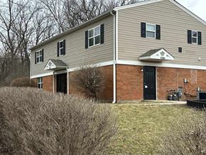 Dayton apartment for rent - A two-story house with a black door and a covered patio.