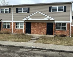 Dayton apartment for rent - A brick house with a black door and a small front yard.