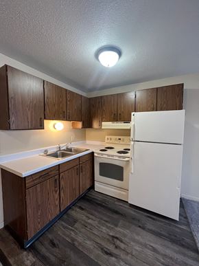Moorhead apartment for rent - A kitchen with white appliances and wooden cabinets.