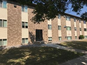 Fargo apartment for rent - A brick building with a black door and windows on the side.