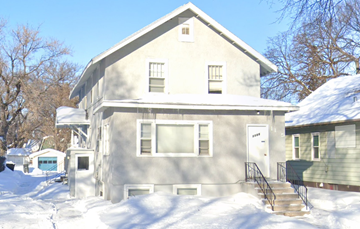 Fargo apartment for rent - A house with a snow-covered front yard.