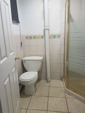 Paterson apartment for rent - A white toilet in a small bathroom with a white door.