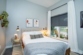 Saint Louis apartment for rent - a bedroom with a bed and a window with white curtains