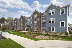 Toms River apartment for rent - an exterior view of an apartment building with a sidewalk