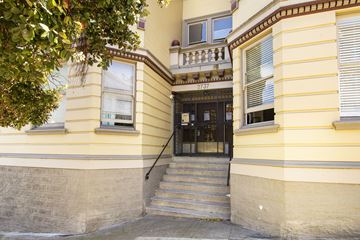 San Francisco apartment for rent - A yellow building with a black door and steps leading up to it.
