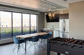 Minneapolis apartment for rent - a dining room with a table and chairs and a foosball game in front