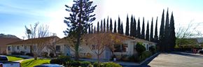 Orange apartment for rent - a house with tall trees in front of it
